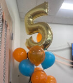 A balloon of the number five surrounded by blue and orange balloons