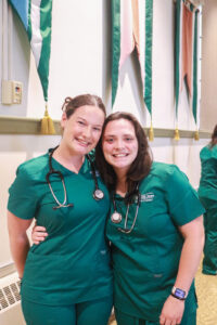 Two PSU nursing students pose with their new stethoscopes