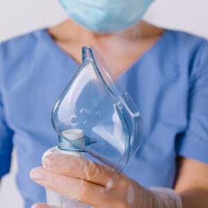 A respiratory therapist holding an oxygen mask