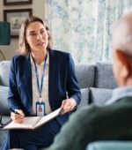 A social worker on a couch talking to a patient