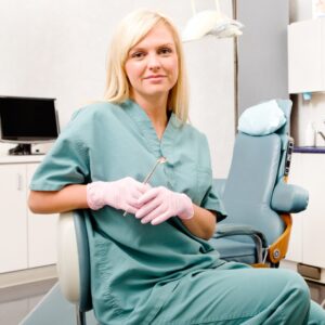 A dental hygienist posing in a dentist's office