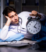 A medical professional tired on the floor with a clock