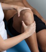 a physical therapist working on a patient's leg